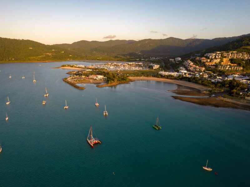 Aerial,View,Overlooking,A,Coastal,Town,With,Multiple,Boats,Anchored