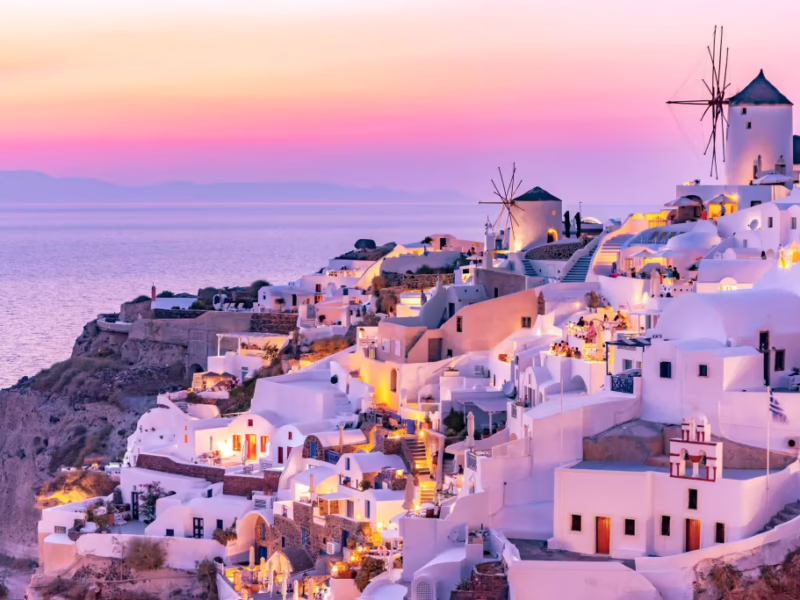 Pink sunset on Santorini, Greece with coastal town in view of ocean